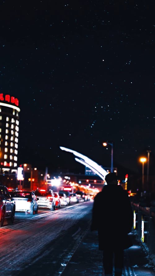 一个人在夜间在城市路边行走 · 免费素材视频