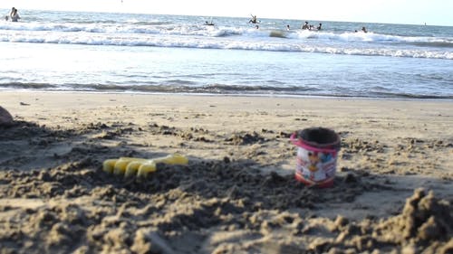 沙玩玩具左躺在沙滩上 · 免费素材视频