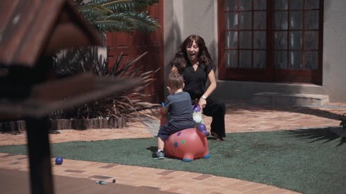 母亲和儿子在他们家门口玩 · 免费素材视频