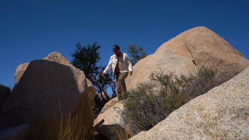 男子站在岩石上 · 免费素材视频