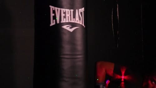一名女拳击手在出气筒上训练 · 免费素材视频