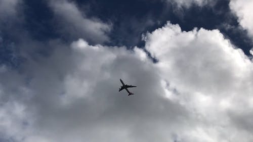 蓝色和多云的天空下飞行的飞机 · 免费素材视频