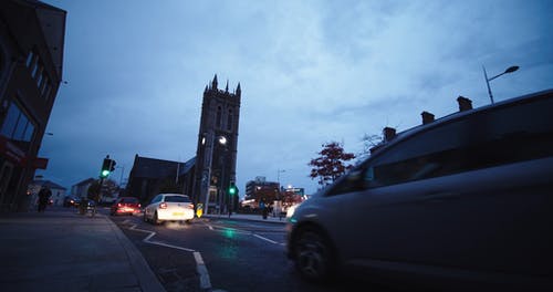 汽车经过教堂的钟声响起的街道时 · 免费素材视频