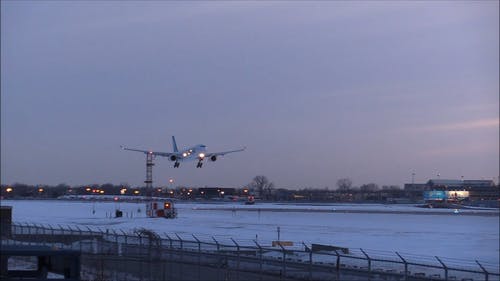 一架飞机降落在机场在冬季冰雪覆盖的领域 · 免费素材视频