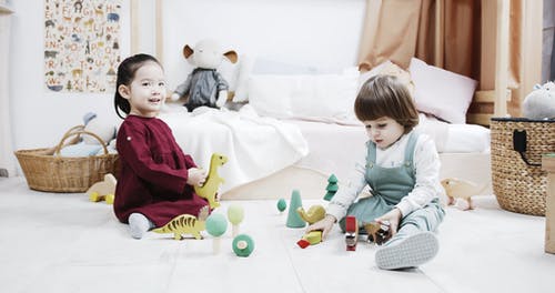 两个孩子在玩木制恐龙玩具 · 免费素材视频