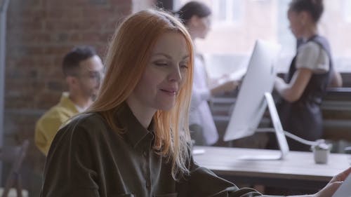 一个女人在使用笔记本电脑时喝咖啡休息成一个微笑 · 免费素材视频