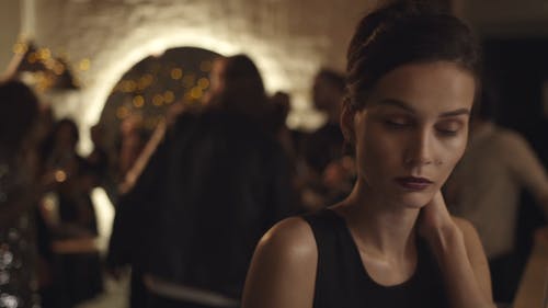 一个单独在酒吧里的女人看着她的肩膀在人群中跳舞 · 免费素材视频