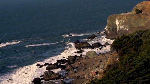 人们在多岩石的海滨上欣赏风景 · 免费素材视频
