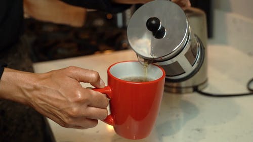 人在一个红色的杯子里倒茶 · 免费素材视频