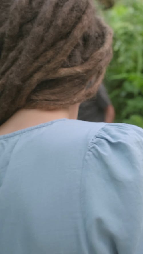 一个女人在花园里使用智能手机拍一张男人照片 · 免费素材视频