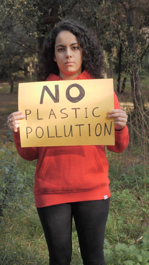 一名妇女在废物处理方面持有aq标语 · 免费素材视频
