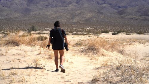 在炎热的日子在沙漠中行走的女人 · 免费素材视频