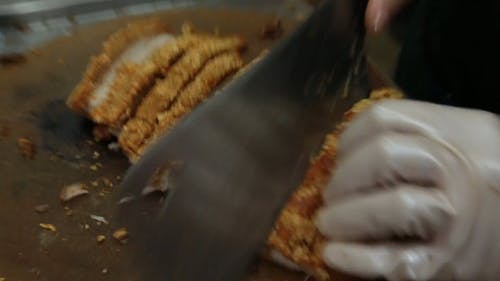 关闭一个人切碎酥脆的猪肉肚在一块木头砧板上的盘子的关闭 · 免费素材视频
