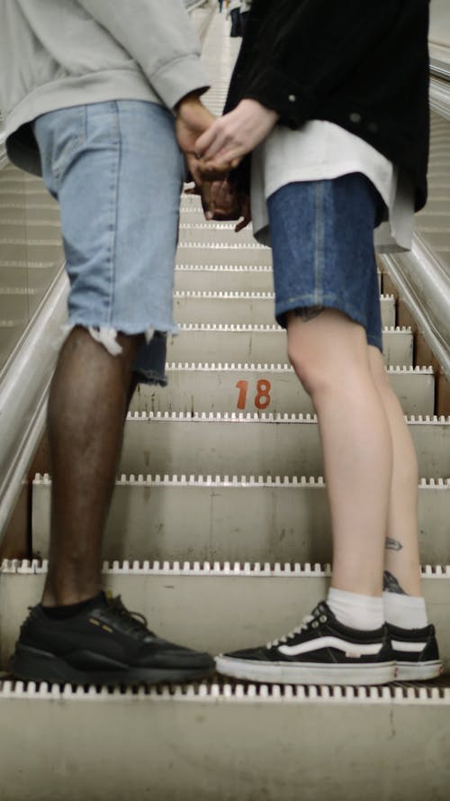 一对夫妇的脚在自动扶梯上 · 免费素材视频