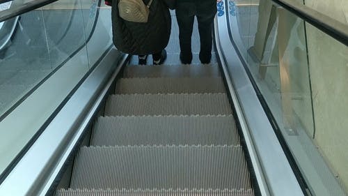 人们使用自动扶梯下楼 · 免费素材视频