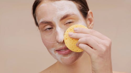 女人用肥皂和海绵清洗她的脸 · 免费素材视频