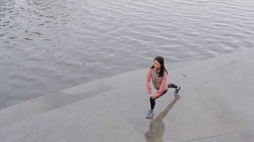 一个女人在河边做伸展运动 · 免费素材视频