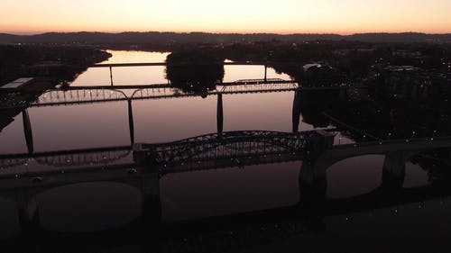 日落时河上的桥梁鸟瞰图 · 免费素材视频