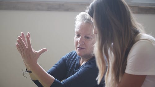 瑜伽教练向女人展示瑜伽姿势 · 免费素材视频