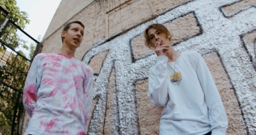 两名年轻男子站在墙上的涂鸦 · 免费素材视频