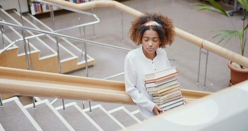 一个年轻女子背着书 · 免费素材视频