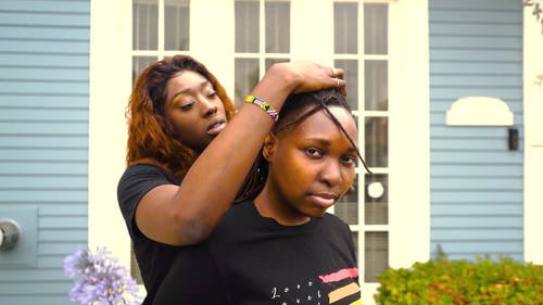一个女人固定她的伴侣的头发 · 免费素材视频