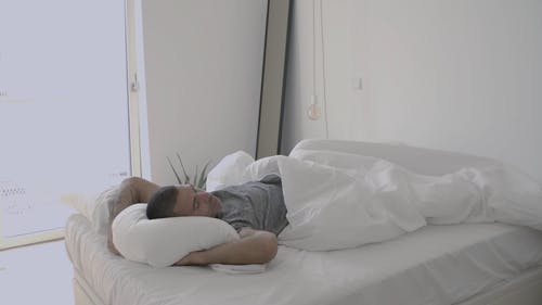 男人在他的床上醒来 · 免费素材视频