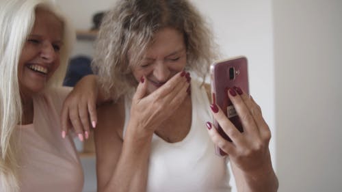 两个女人看着智能手机很开心 · 免费素材视频