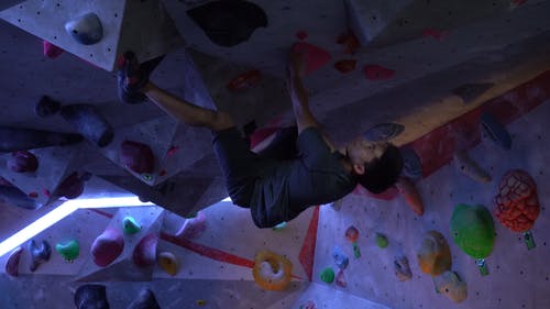 一个男人挂在攀岩墙上 · 免费素材视频