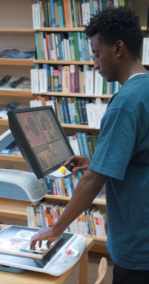 一个年轻人在图书馆内使用计算机 · 免费素材视频