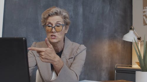 女人在使用她的笔记本电脑时与人交谈的视频 · 免费素材视频