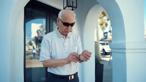 一位老人在等待时看着时间 · 免费素材视频