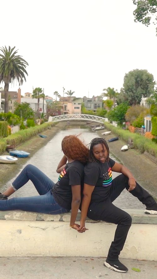 背靠背坐在桥架上的两个女人 · 免费素材视频