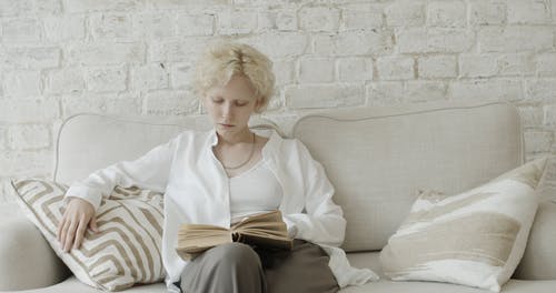 坐在沙发上看书的女人 · 免费素材视频