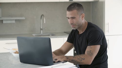 一个人在用笔记本电脑水龙头时喝咖啡 · 免费素材视频