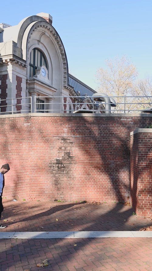 一个男人准备爬上砖墙 · 免费素材视频