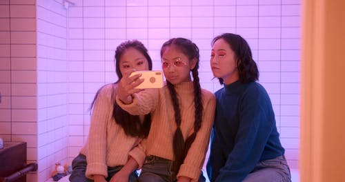 三姐妹使用智能手机拍照 · 免费素材视频
