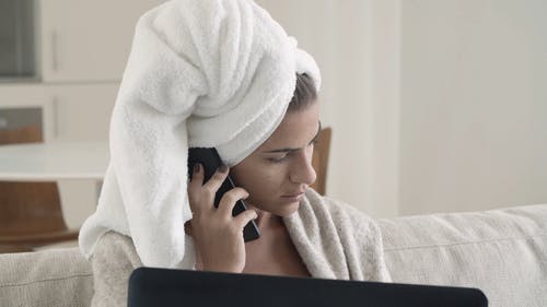 一个女人在打个电话时在她的笔记本上工作 · 免费素材视频