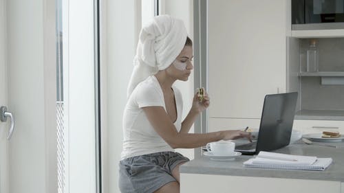 一个女人在用笔记本电脑工作时吃早餐 · 免费素材视频