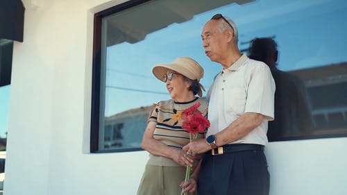 一位老人在妻子旁边抱着一束鲜花 · 免费素材视频