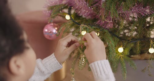 一个小男孩装饰一棵圣诞树 · 免费素材视频