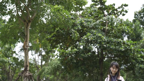 一个女人拿着她的智能手机到户外散步 · 免费素材视频