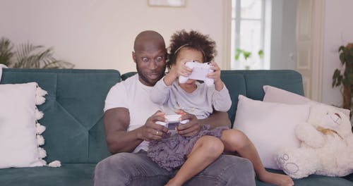 爸爸和女儿一起玩电子游戏 · 免费素材视频
