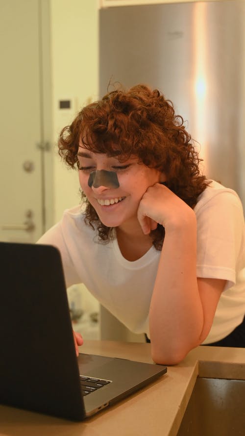 一个女人在使用笔记本电脑时咯咯地笑 · 免费素材视频