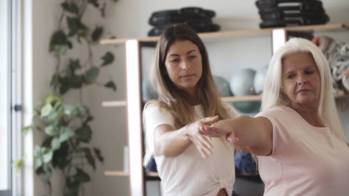 一位瑜伽教练帮助一个女人的姿势 · 免费素材视频