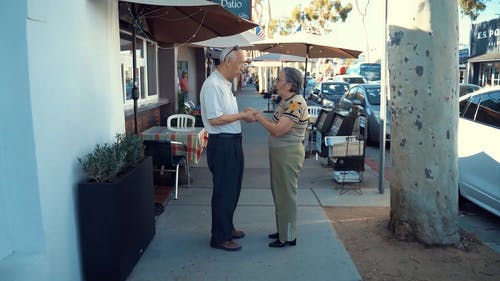 老夫妇牵着的手在大街上 · 免费素材视频
