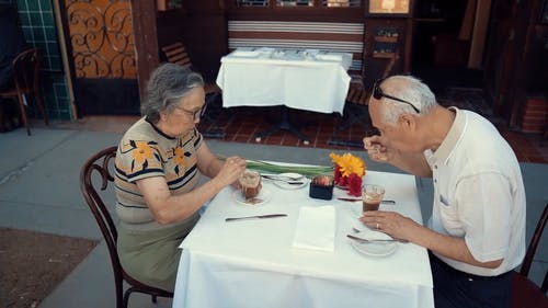 一对老年夫妇在一家露天餐厅吃饭 · 免费素材视频