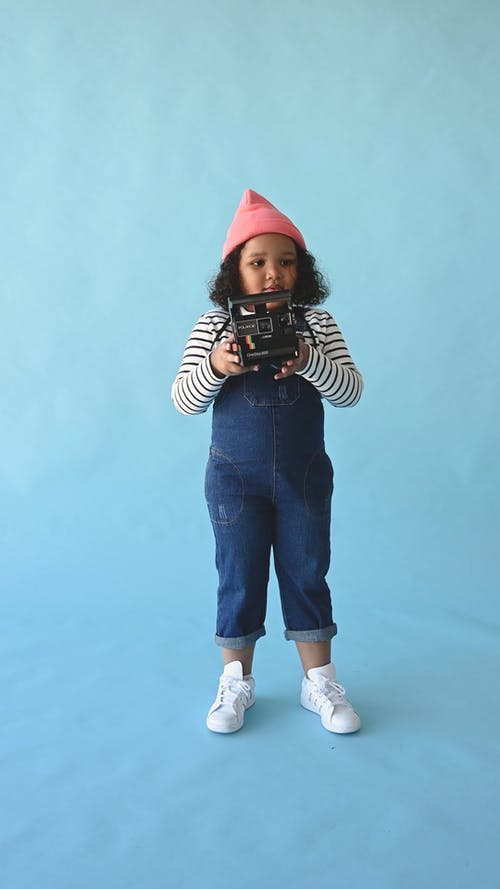 一个小女孩拿着宝丽来相机 · 免费素材视频