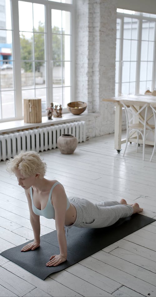 一个女人在家里做弯曲运动 · 免费素材视频