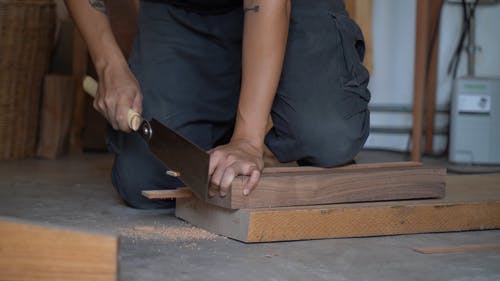 一个男人用后锯切木头 · 免费素材视频